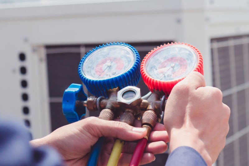 Technician is checking air conditioner ,measuring equipment for filling air conditioners.